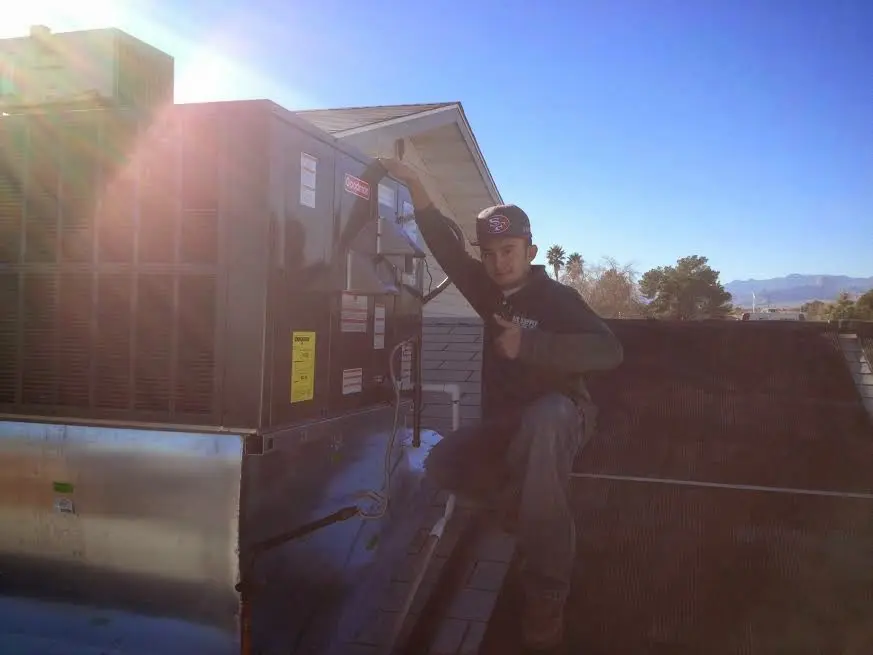 HVAC technician performing HVAC Inspection on a rooftop unit in Orchards